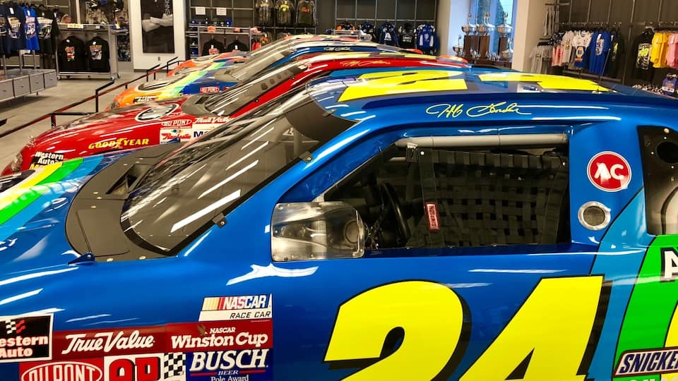 A row of NASCAR race cars in a store.
