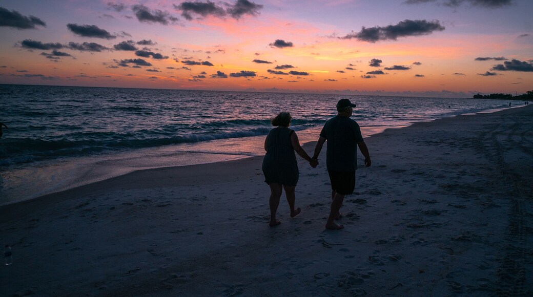 A couple walking under sunset beautiful sky at Anna Maria Beach Beadeton Florida