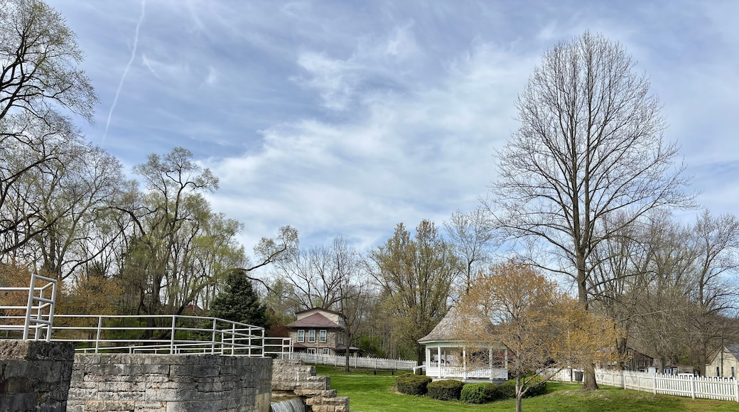 Stone canal lock and waterfall beside gazebo in peaceful town park