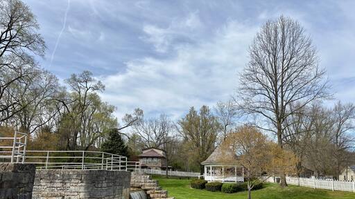Stone canal lock and waterfall beside gazebo in peaceful town park