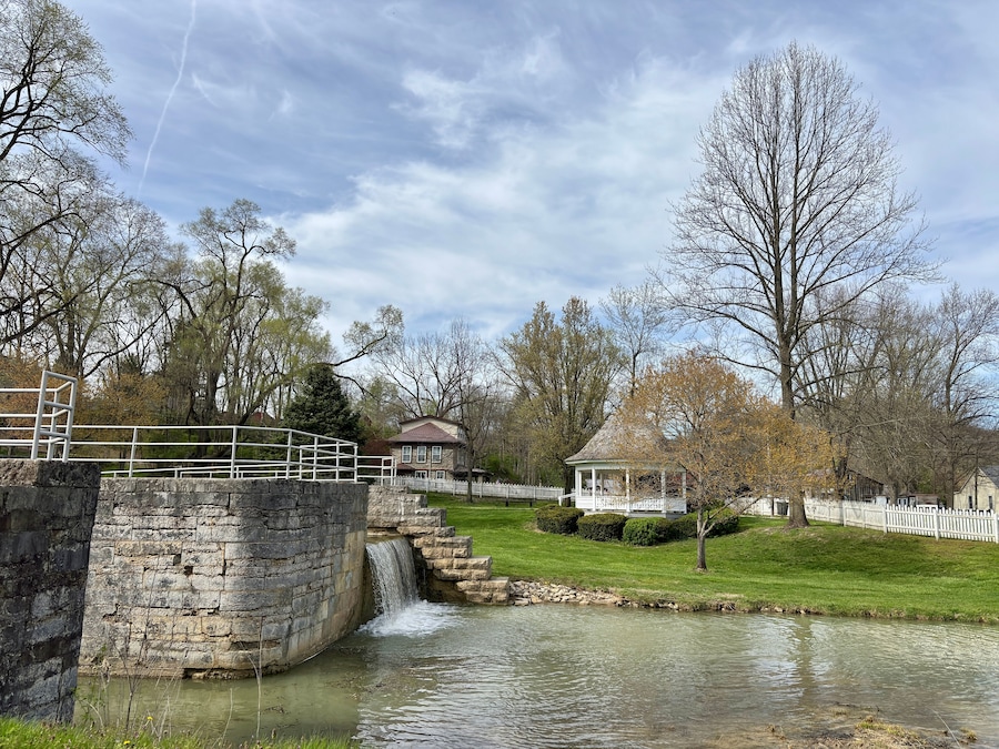 Stone canal lock and waterfall beside gazebo in peaceful town park