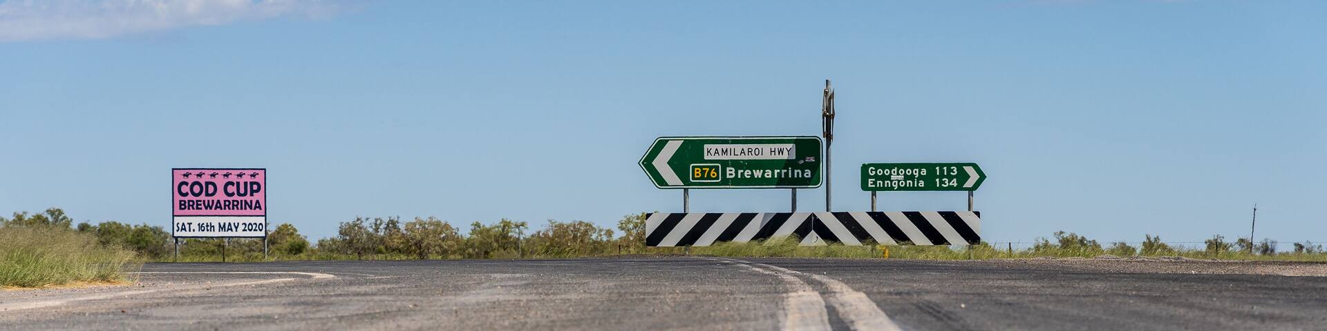 Low angled view of a line down the centre of an outback road leading to a traffic sign