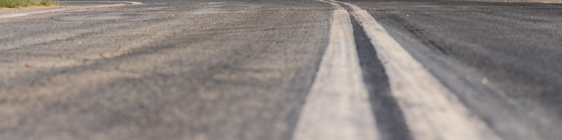 Low angled view of a line down the centre of an outback road leading to a traffic sign