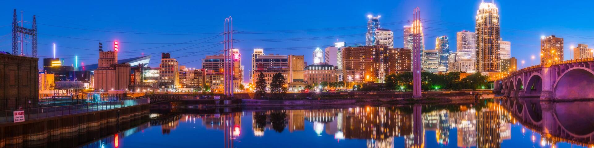 Minneapolis skyline with reflection in river at night.