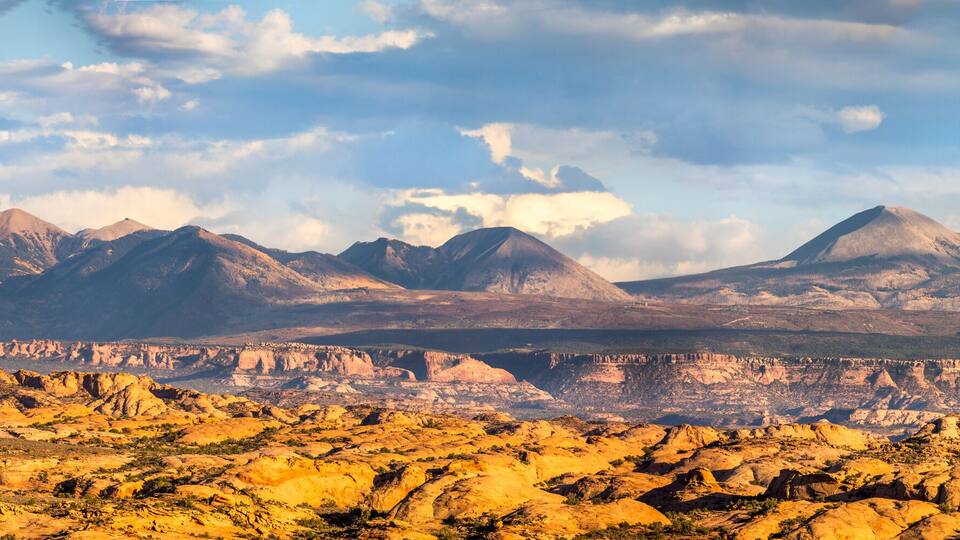A mountainous landscape with prominent peaks and a rocky foreground.