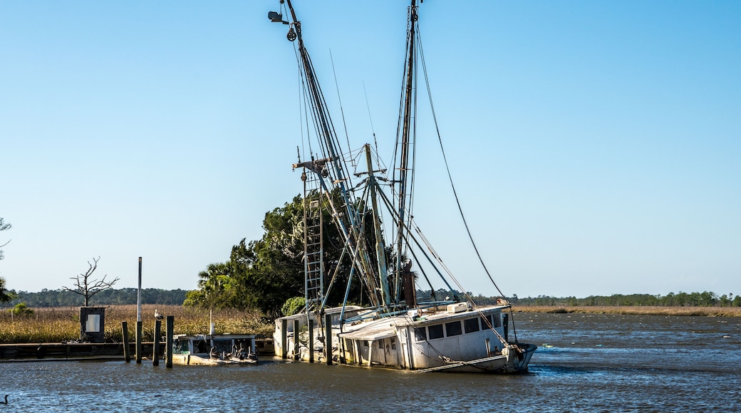 Sunken shrimp boats are still tied to the dock in apalachicola Florida. These boats were abandoned after sinking in a storm or hurricane .
