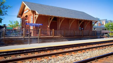 Uma estação de trem de tijolos com o nome 'GAITHERSBURG', plataforma de madeira e trilhos.