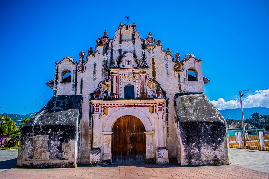 Una iglesia histórica con una gran puerta de madera y fachada ornamentada.
