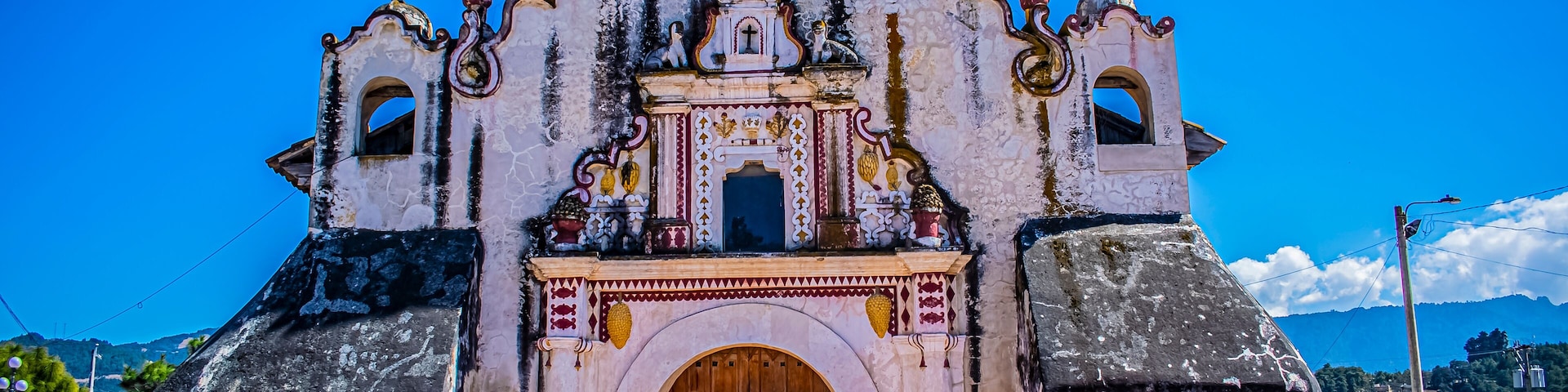 Una iglesia histórica con una gran puerta de madera y fachada ornamentada.