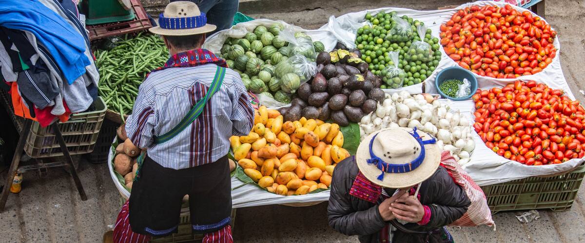 A street market with vendors selling fruits and vegetables.