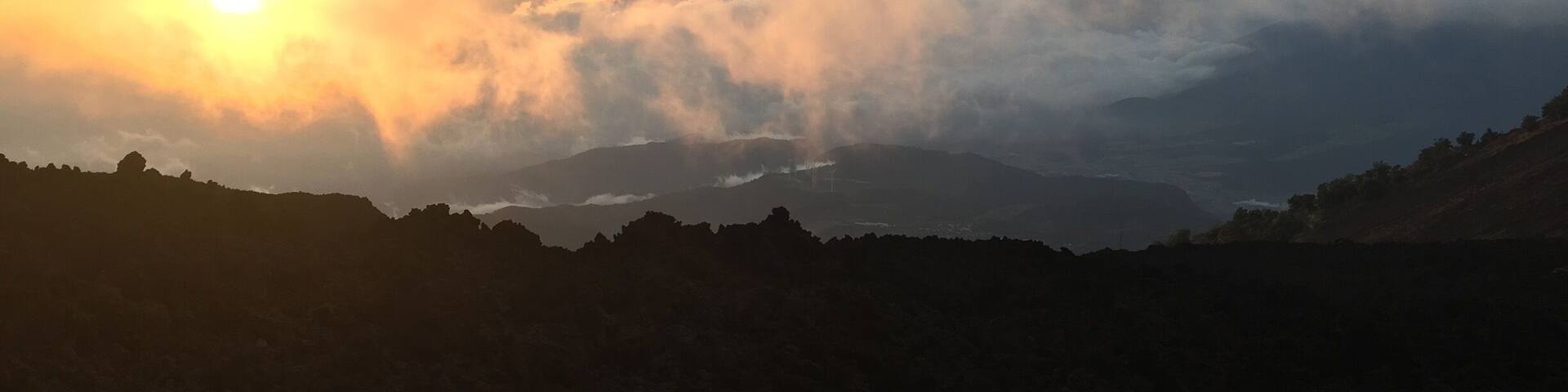 Cordillera con un atardecer y nubes.