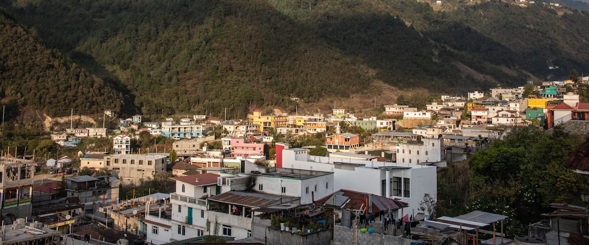 A town nestled in a valley with mountains in the background.