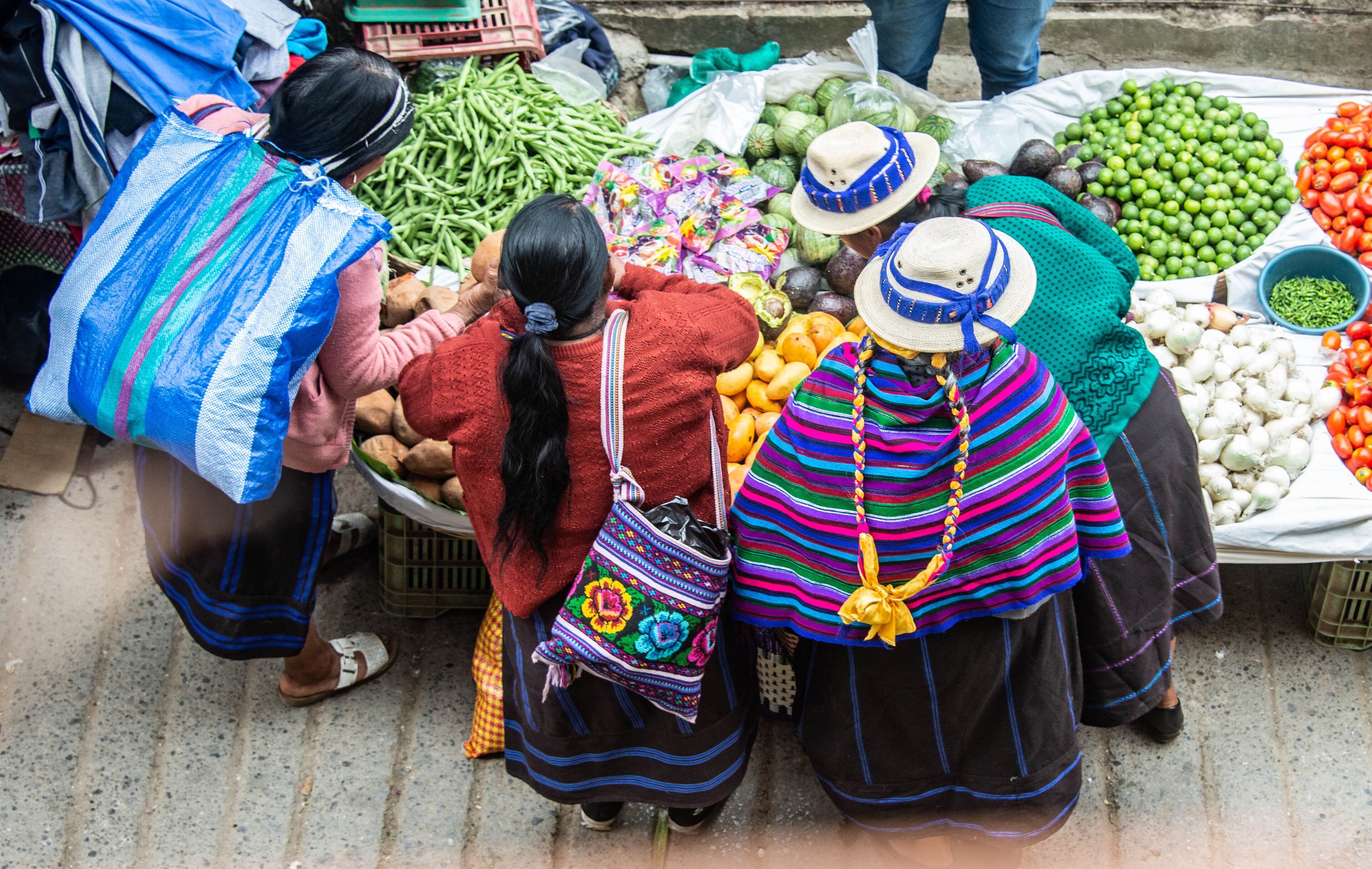 A market with vendors selling vegetables and fruits.