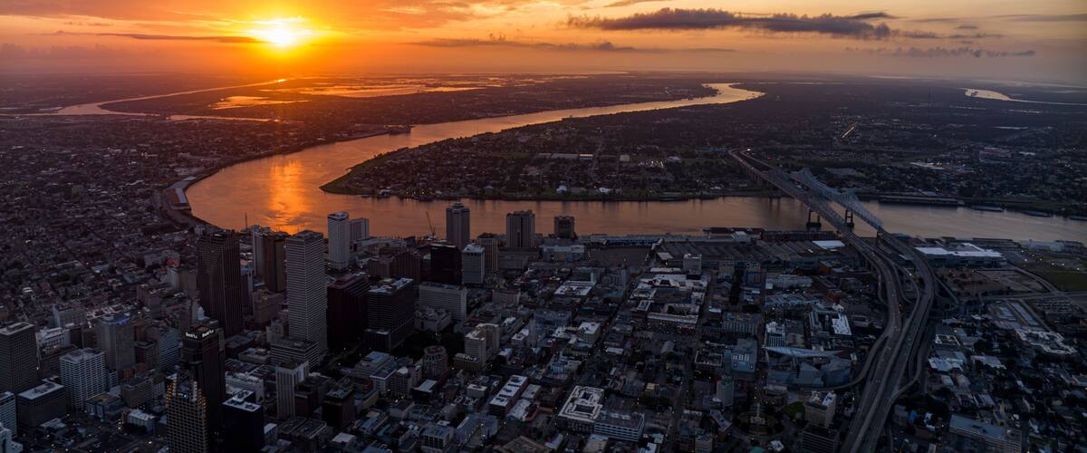 A sunset over a city with a river, bridges, and high-rise buildings.