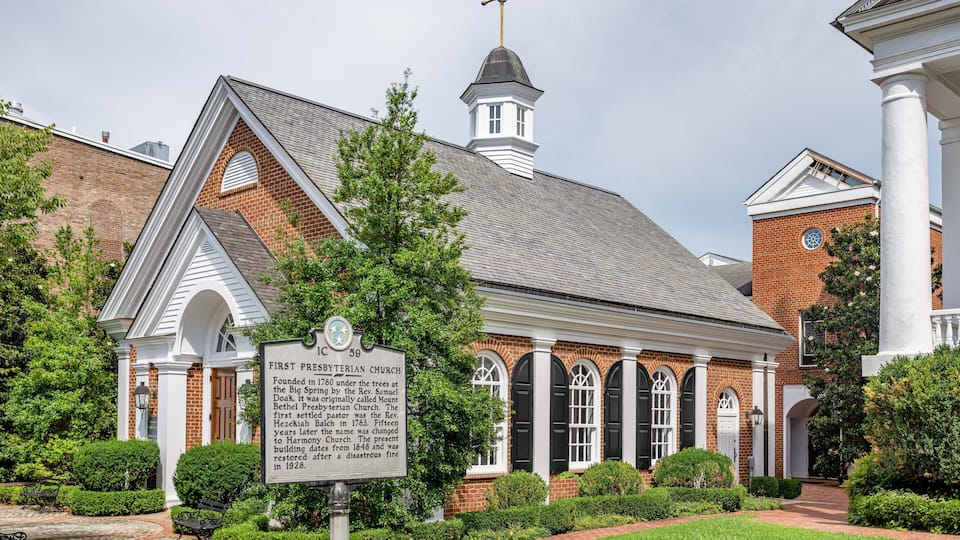 A historic church with a brick facade, white columns, and a steeple.