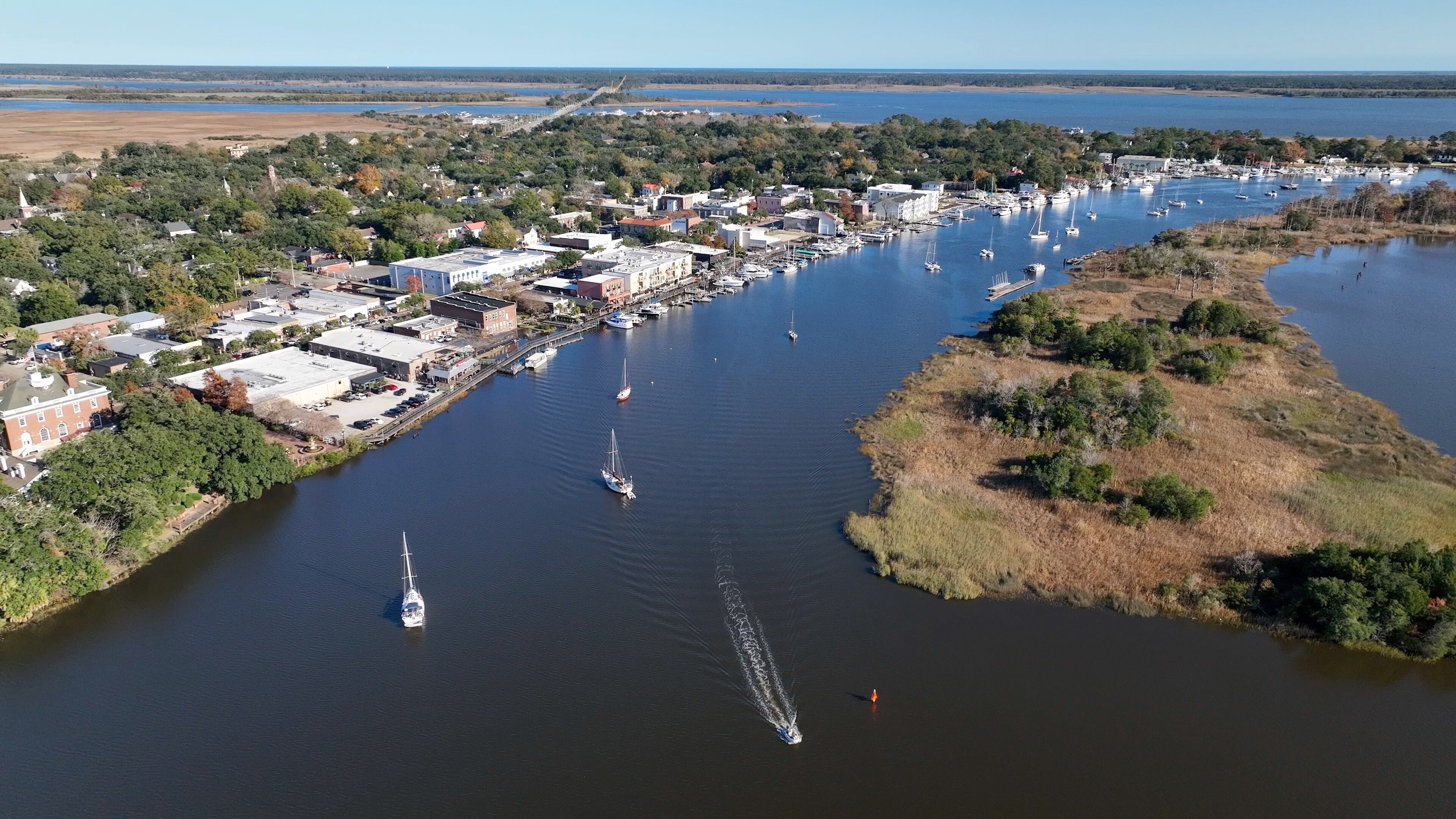 Cars and boats in small town USA historic Georgetown, SC with front street business and homes by Winyah Bay waterway in South Carolina Low Country