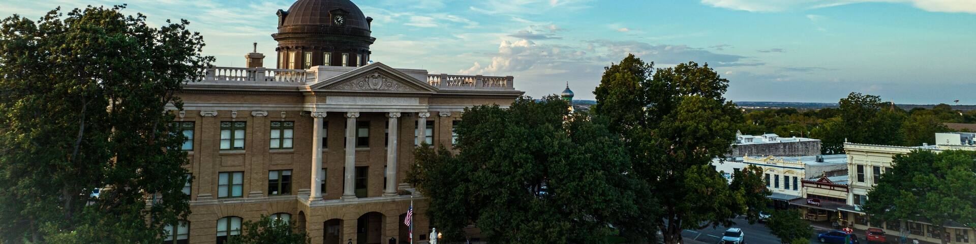 Architecture of Courthouse in Georgetown, Texas with street view, cars, trees and cloudy sky