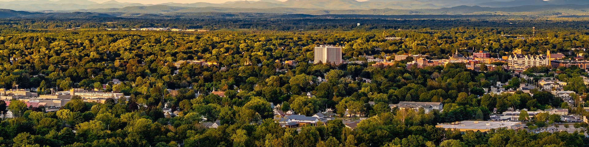 Queensbury, NY, USA - August 27, 2025: Late afternoon aerial view of a rainbow over the Queensbury / Glens Falls area near the southern boundary of the Adirondack Park of of Interstate 87.