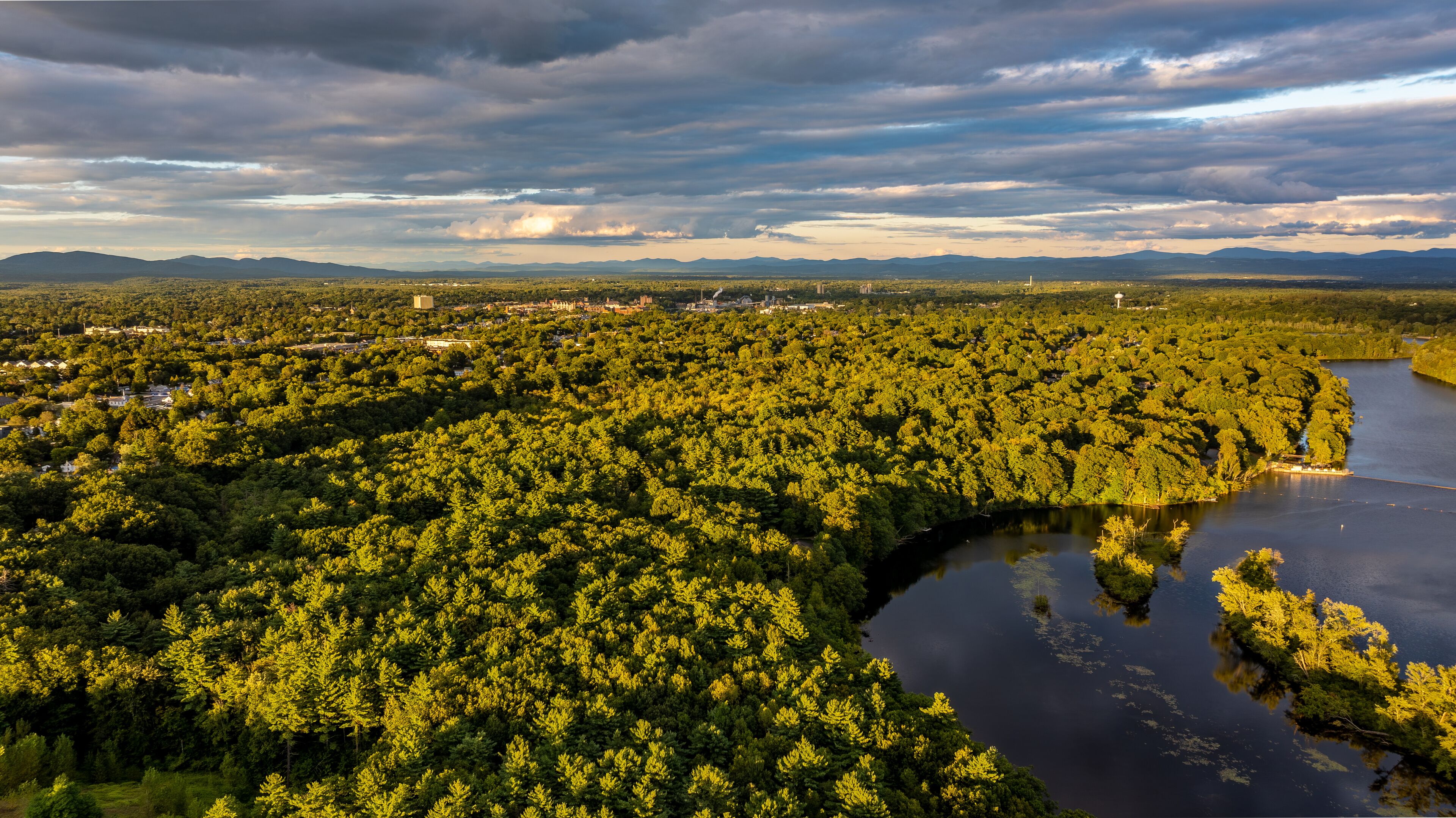 Queensbury, NY, USA - August 27, 2025: Late afternoon aerial view over the Queensbury, NY, and the Hudson River, near the southern boundary of the Adirondack Park of of Interstate 87.	