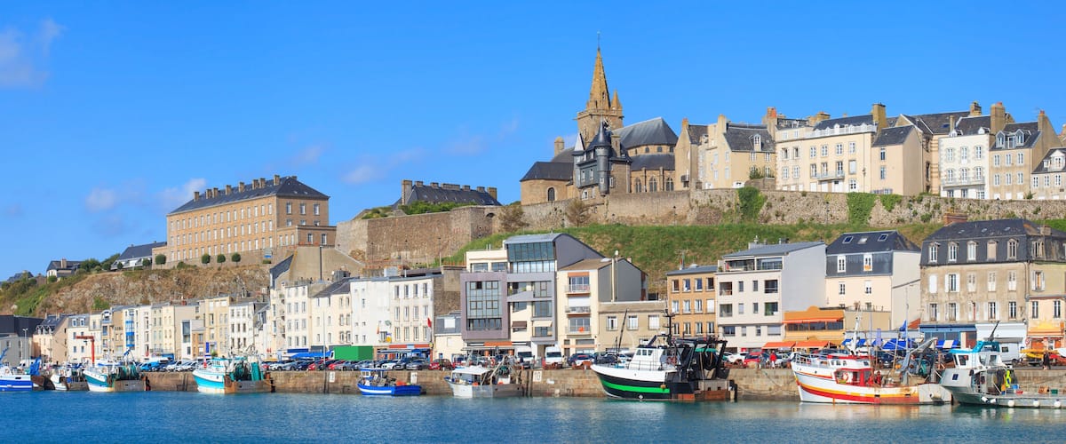 A harbor with boats, a historic building, and a church.