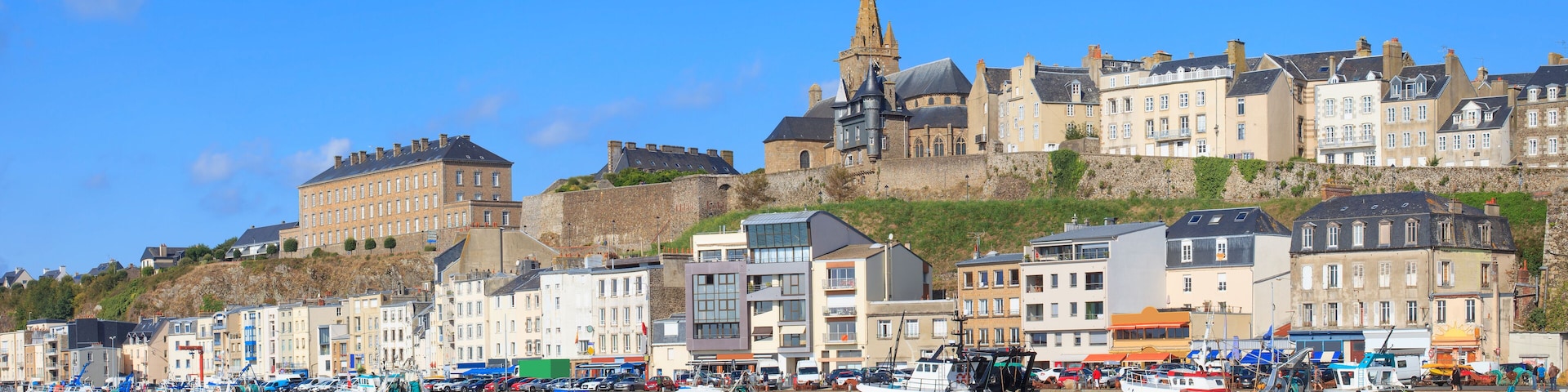 A harbor with boats, a historic building, and a church.