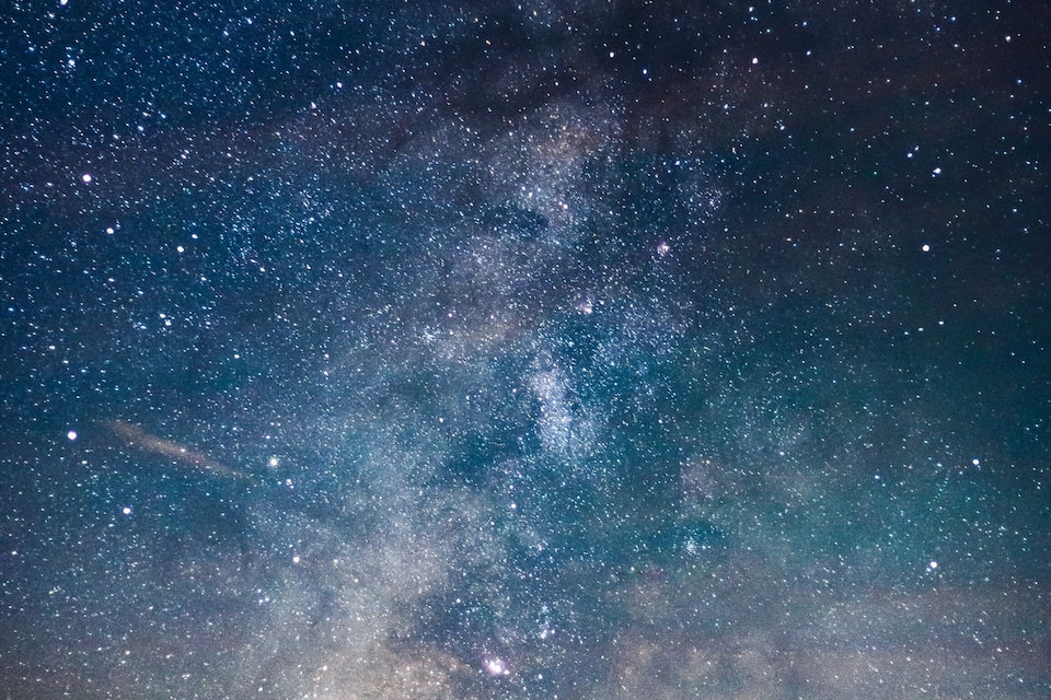 Cielo estrellado sobre un paisaje montañoso.