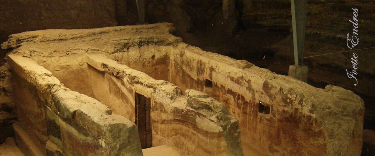 An ancient, partially excavated structure with a rectangular layout and a central doorway.