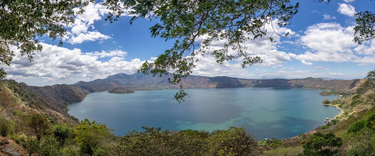 A large lake surrounded by mountains and dense forest.