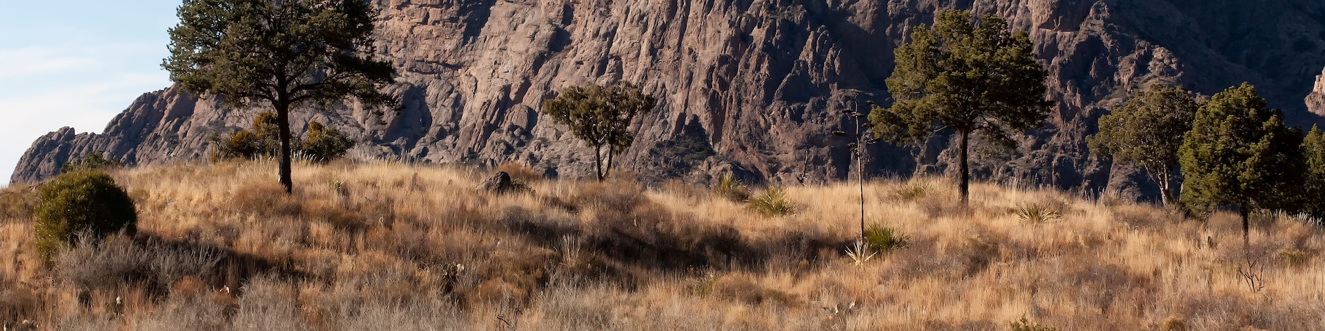 Un paisaje montañoso con una persona haciendo senderismo.