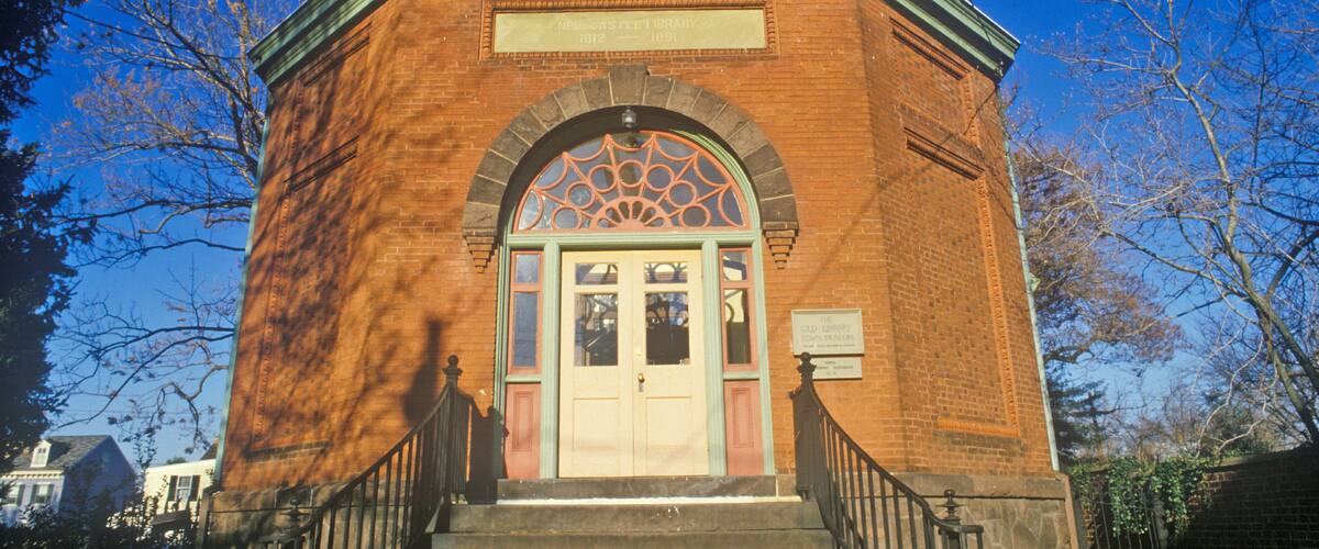 A brick building with a green roof and a decorative entrance.