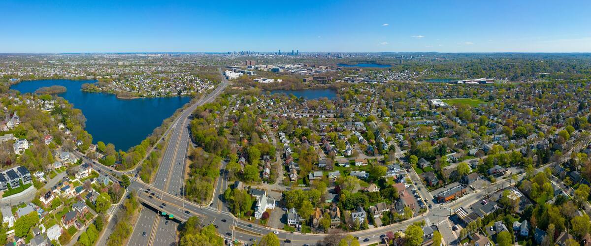 An aerial view of a city with two large lakes, a highway, and residential areas.