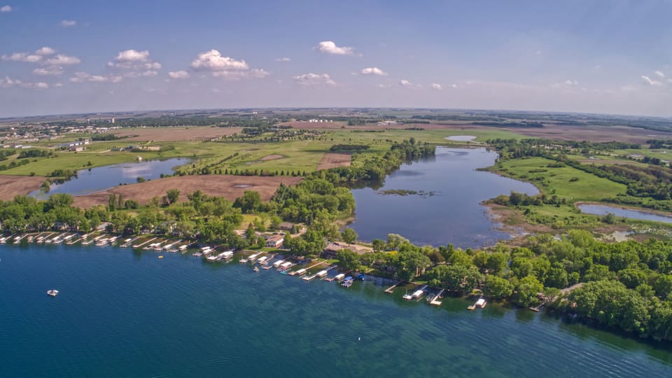 A river meandering through a green landscape with a marina and boats.
