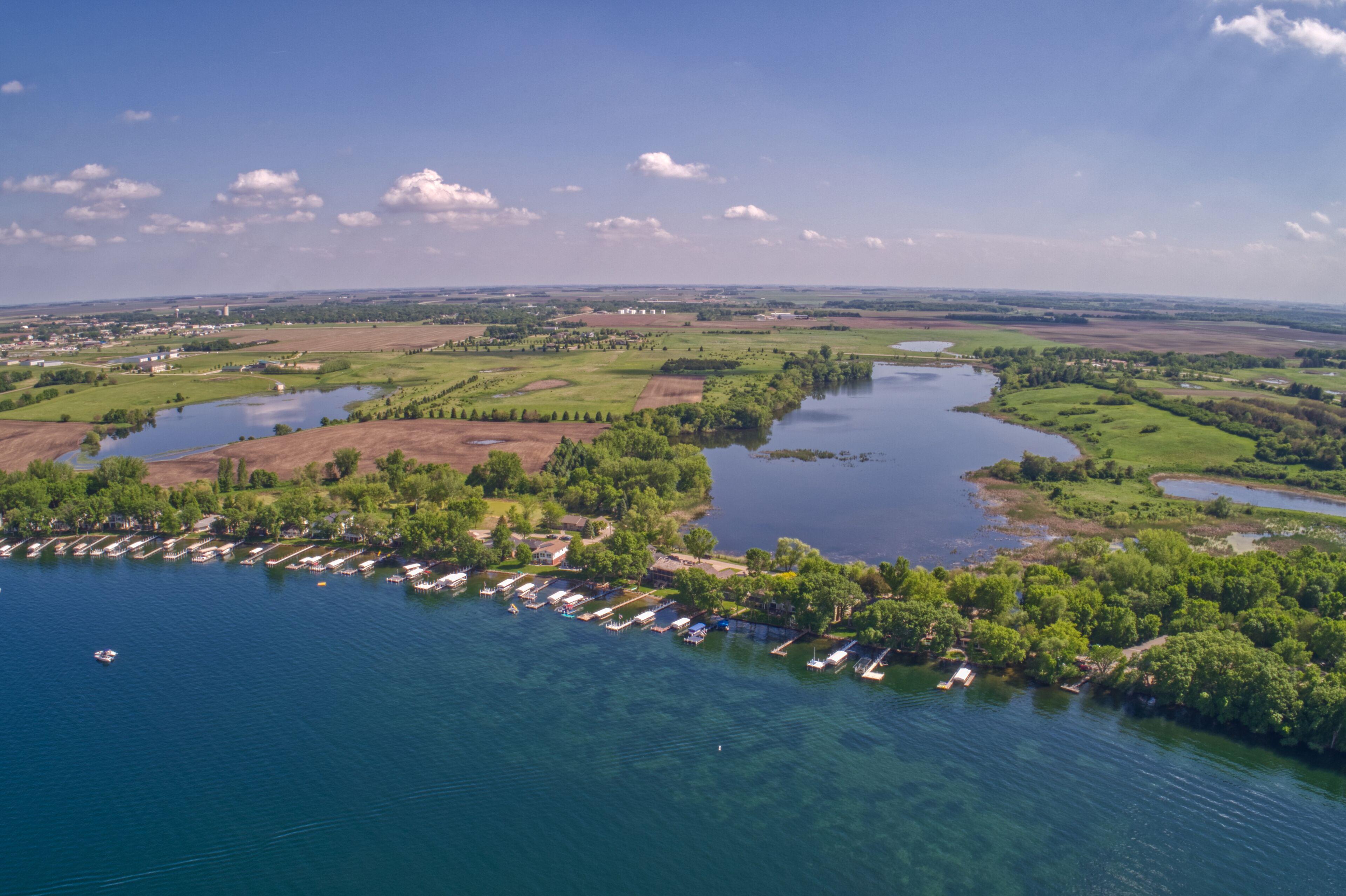 A river meandering through a green landscape with a marina and boats.