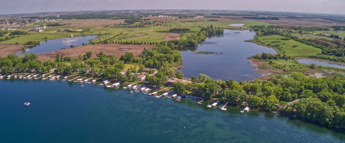 A river meandering through a green landscape with a marina and boats.