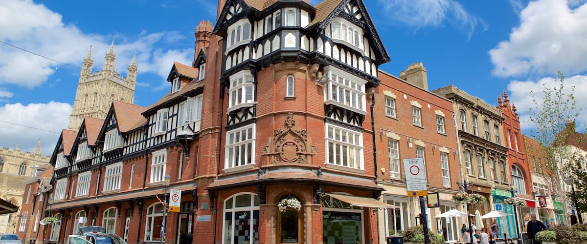 A historic building with Tudor-style architecture, a prominent clock tower, and a pedestrian zone sign.
