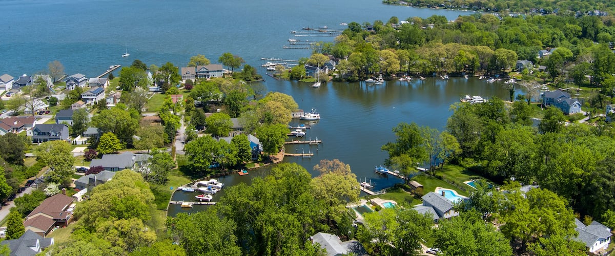 A lakeside residential area with houses, docks, and boats.