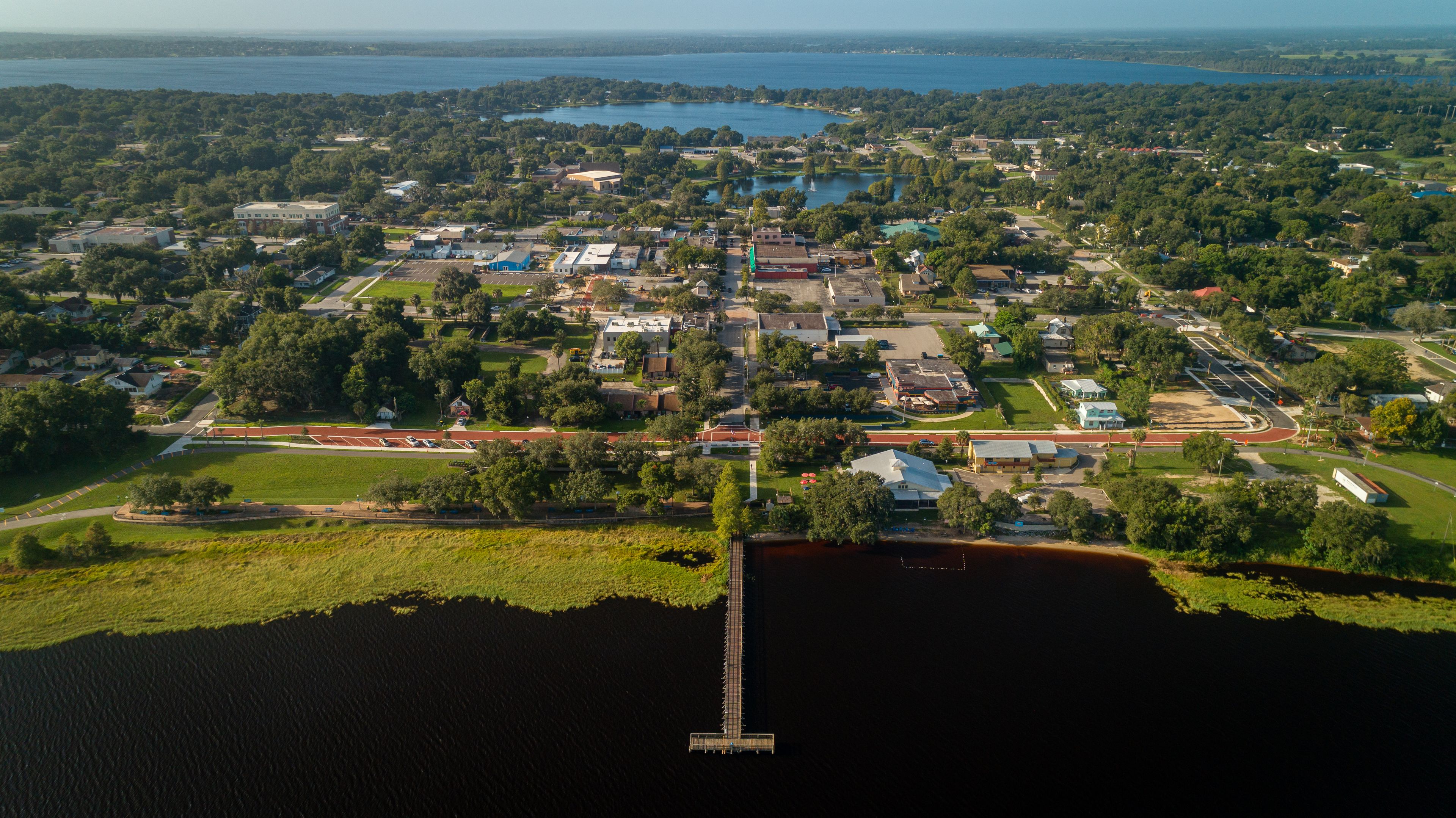High altitude aerial view over the Lake Minneola lakefront pier in downtown Clermont, Florida.