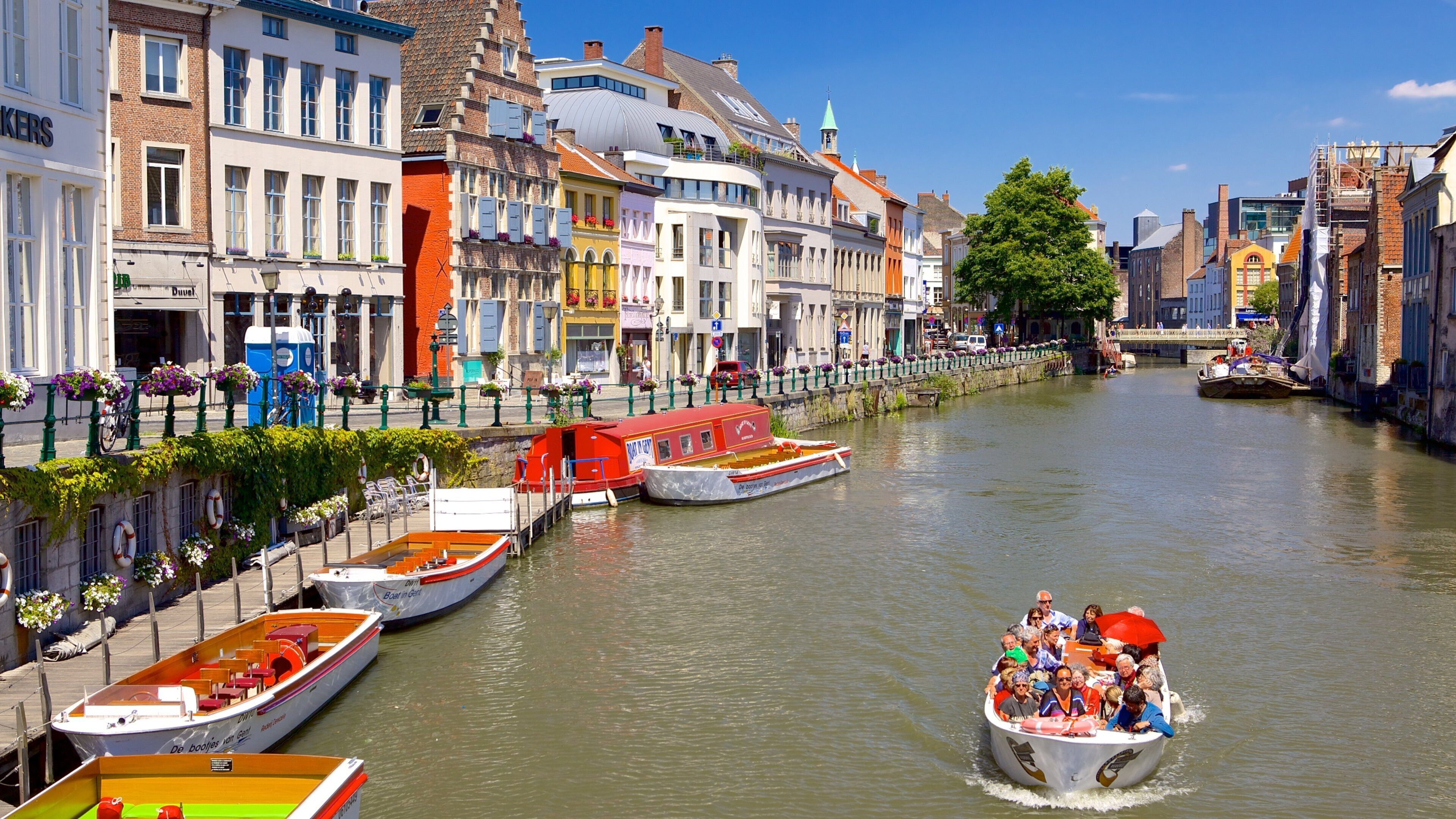 A canal with boats, historic buildings, and a bridge.