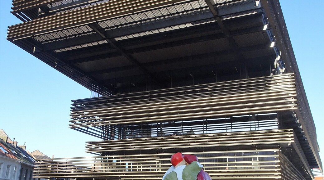 City library "De Krook" was built in 2017 by architects Coussée & Goris and Aranda Pigam Vilalta Arquitectes.
The sculpture group in front, 3 metres high, is a work by artist Michaël Borremans*. It shows a group of 4 people, each with a different skin colour, leaning their heads against each other. The work symbolizes the exchange of knowledge and culture at the Krook. #Ghent #Trovember #Architecture #Art
*Michaël Borremans is a Belgian painter and sculptor. Borremans' work can be seen in the collections of, among others, the Museum of Contemporary Art in Los Angeles, the San Francisco Museum of Modern Art, the Museum of Fine Arts in Boston, the Museum of Modern Art in New York and the Art Institute of Chicago.