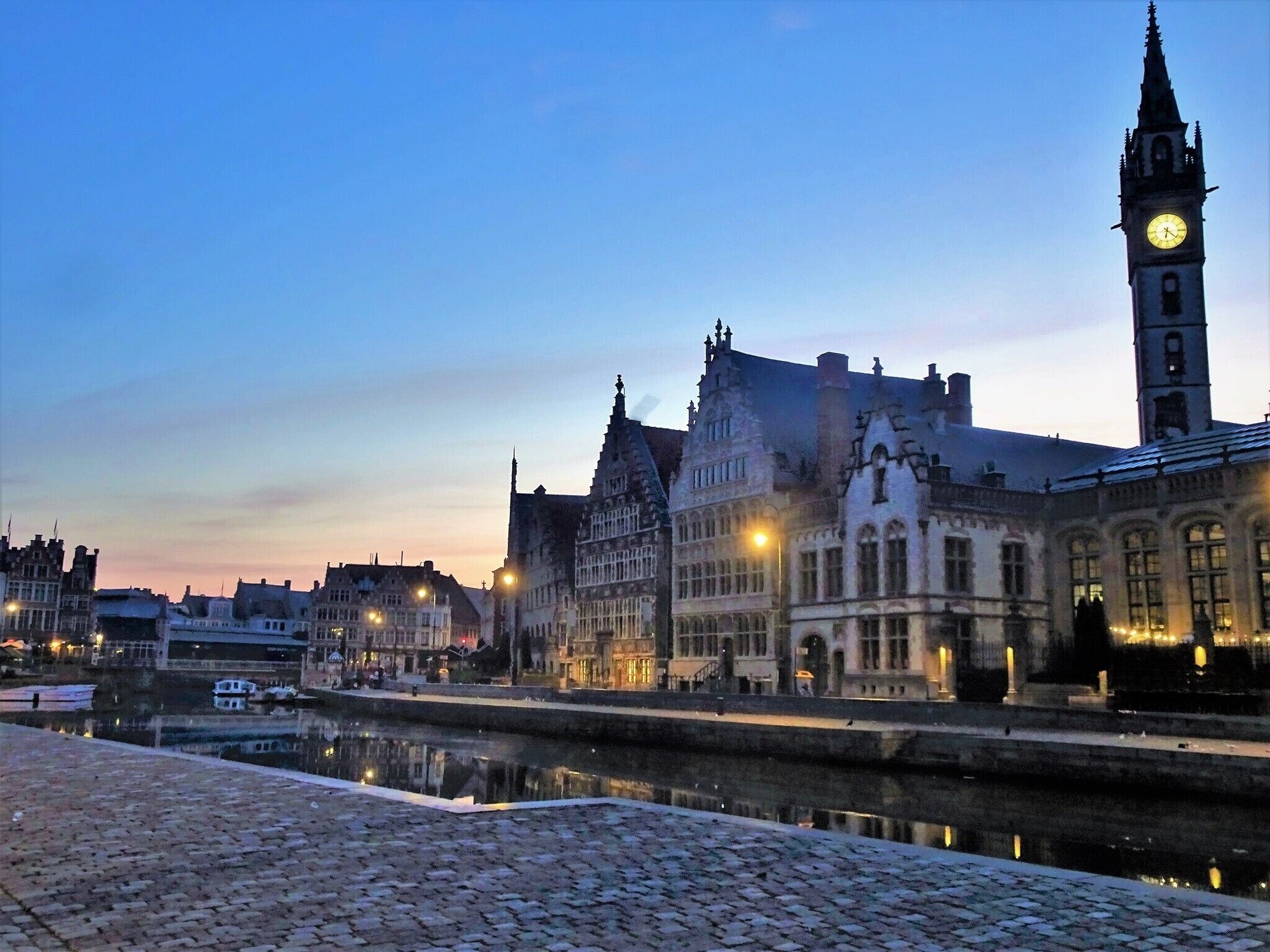 A summer day at 6:20 am.
Sunrise in the city centre: this is the river Leie and the place where the old harbour of Ghent started its activities in the 11th century. It was then called “Tussen Brugghen” (between bridges). In the background the picturesque Graslei (without tourists, very exceptional).  #Ghent #History