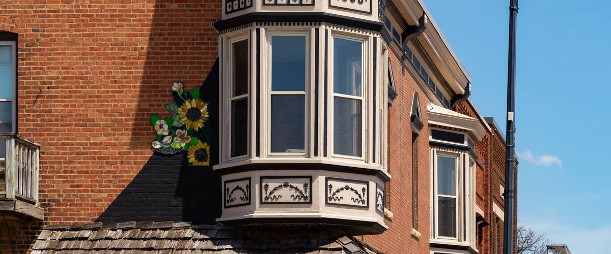 A corner bay window with a decorative frame and a sign reading "STARK 1900."