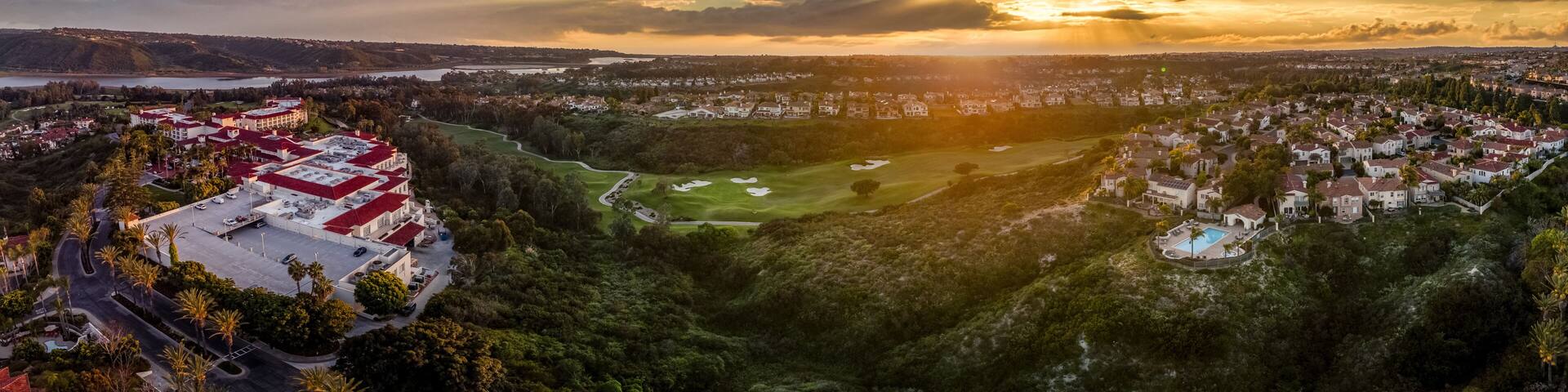 Aerial view of real estate development, luxury villas, single family homes in California near the Pacific Ocean over a gulf course