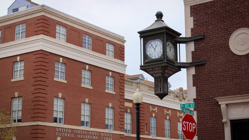 A historic building with a clock and a stop sign.