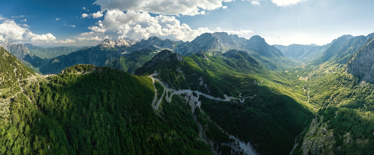 A mountainous landscape with a winding road through a valley.