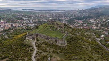 An aerial view of a historic fortress surrounded by a town and a river.