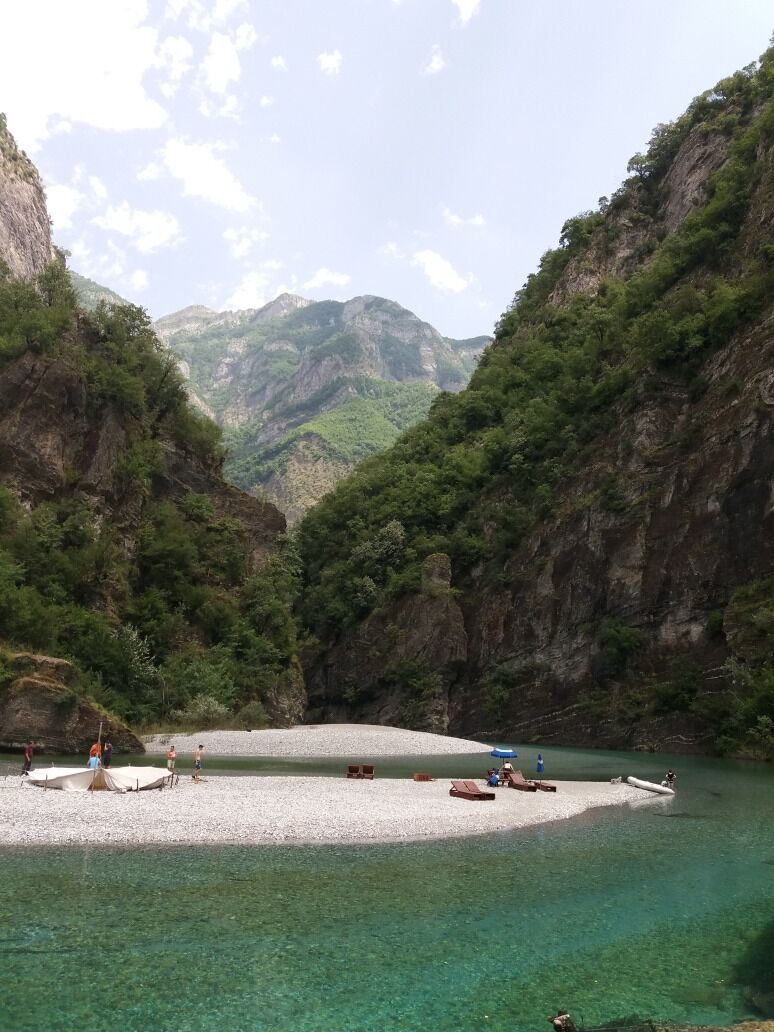 A clear lake surrounded by steep cliffs with a small island in the center.