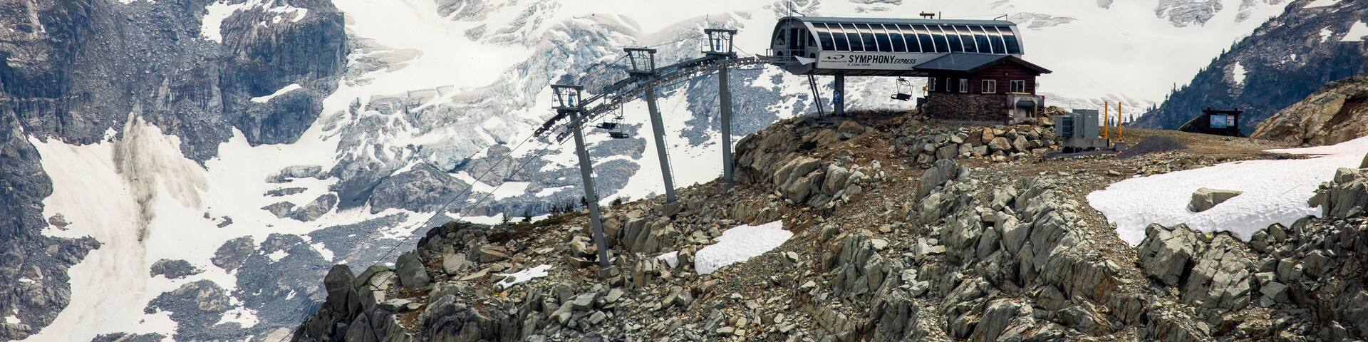 A mountain with a ski lift and a cabin.