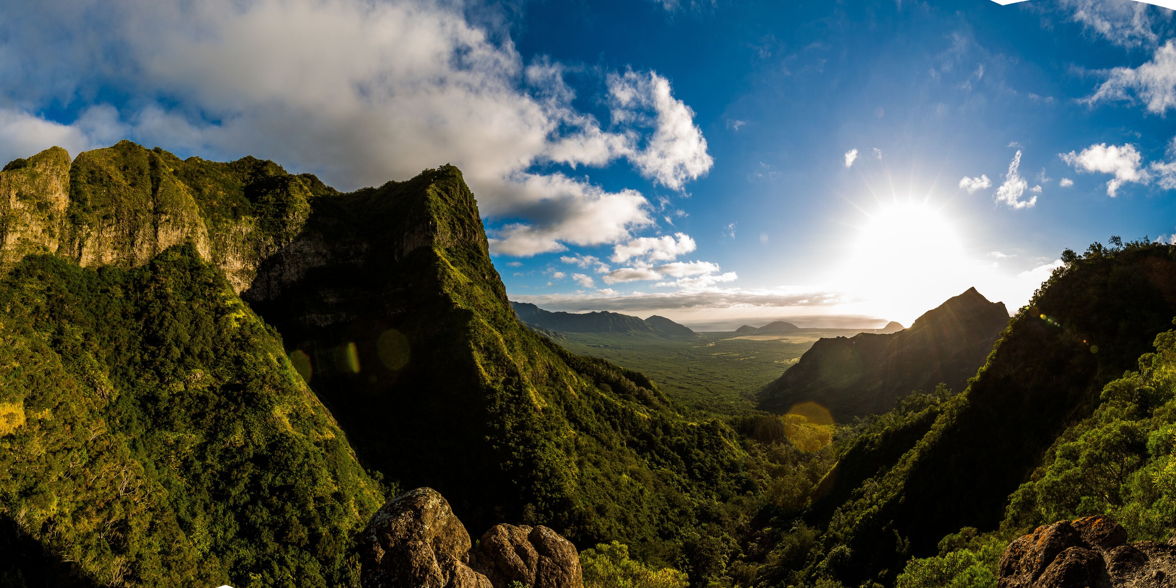 A mountainous landscape with lush greenery and a clear sky.