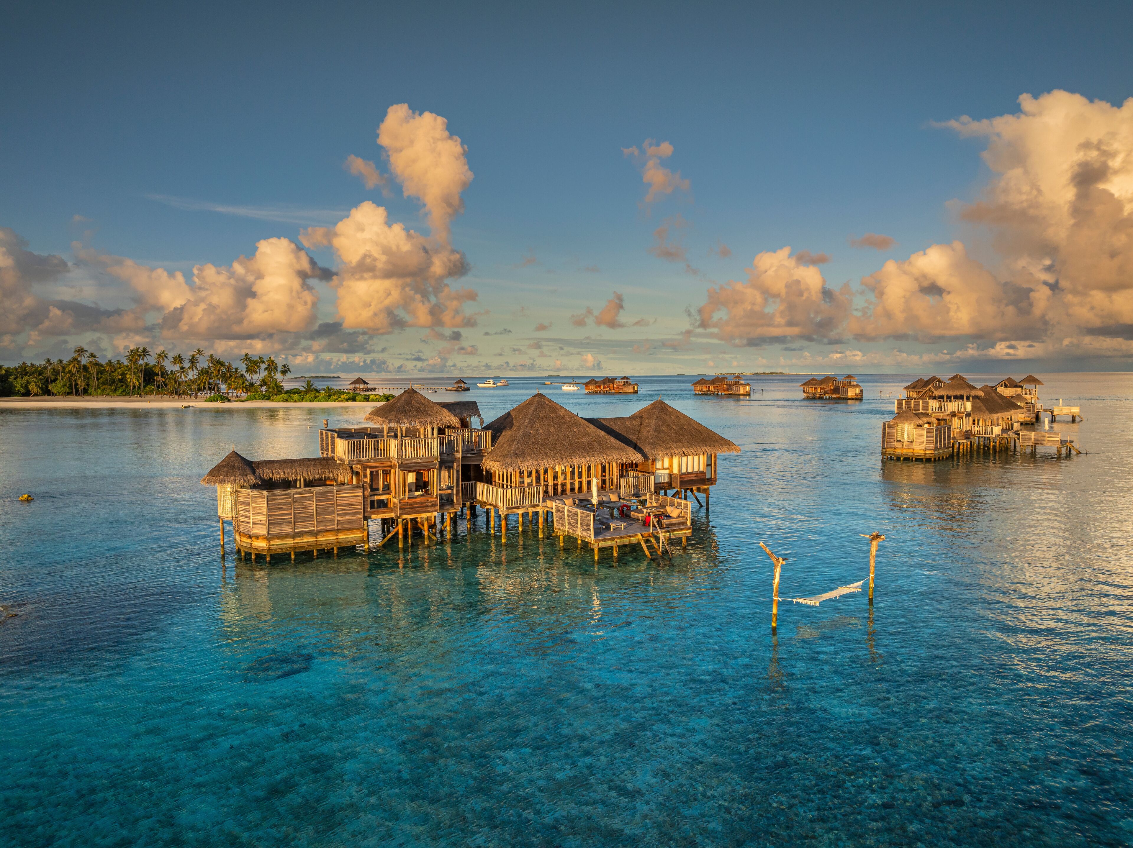 Aerial view of idyllic luxury resort bungalows on a beautiful tropical island with turquoise ocean and sandy beach, Amingiri, Male Atoll, Maldives.