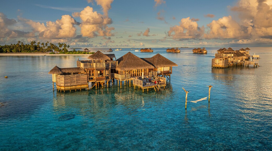 Aerial view of idyllic luxury resort bungalows on a beautiful tropical island with turquoise ocean and sandy beach, Amingiri, Male Atoll, Maldives.